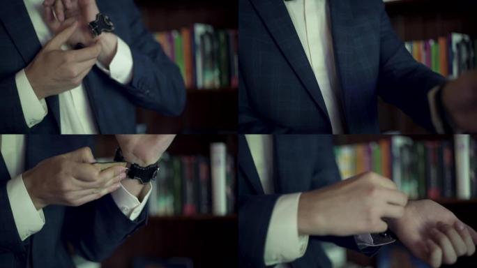 晨间新郎的准备工作。穿着蓝色燕尾服的人戴上手表并将其固定在书架附近的手腕上。新郎正在为婚礼做准备。服