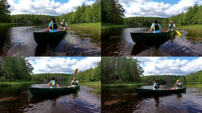 成熟的夫妇在芬兰的森林湖上划独木舟。