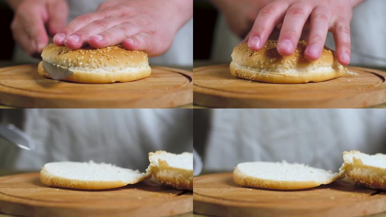 厨房里的厨师用一把大刀将新鲜面包和汉堡包切成两半
