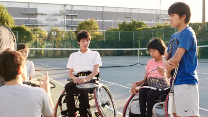 SLO MO广角镜头的教练谈话的一个团队的适应性网球运动员