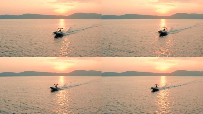 一名女子在日落时驾驶快艇的无人机镜头。