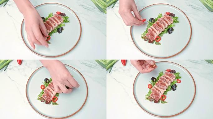 将烤金枪鱼和装饰蔬菜放在4k的盘子里。调味金枪鱼的概念，并补充不同的香料，香菜，葱，红辣椒，蒜片。