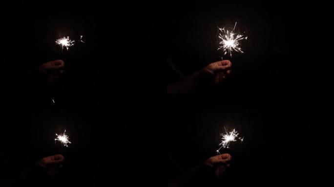 在黑暗的背景上，用手中的火花燃烧火花。固定。概念，圣诞节和新年庆祝活动