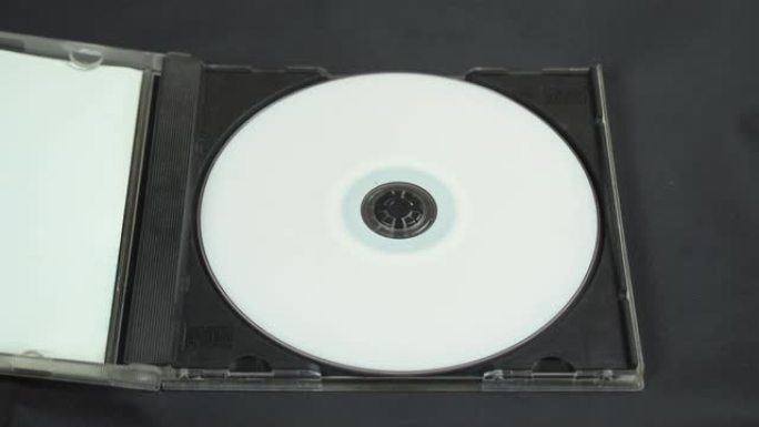 用手拿起并将白色CD DVD光盘安装在塑料盒中。
