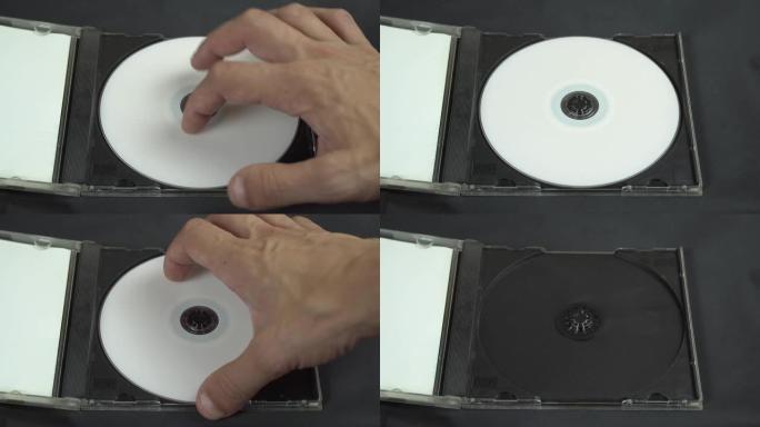 用手拿起并将白色CD DVD光盘安装在塑料盒中。