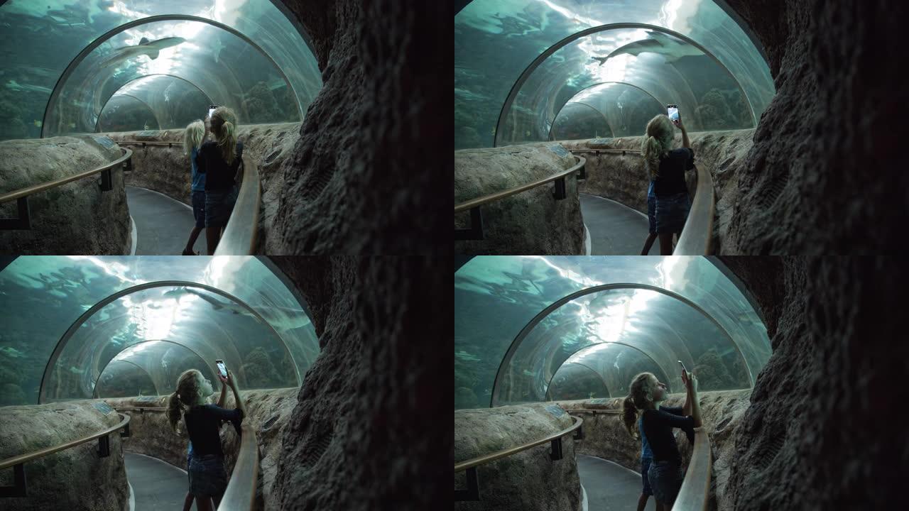 女孩在水下隧道中与小男孩合影