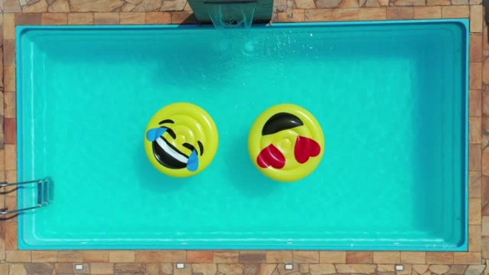 鸟瞰图的微笑表情浮在游泳池。漂浮微笑表情漂浮在游泳池。自顶向下查看微笑表情浮在游泳池。放松。