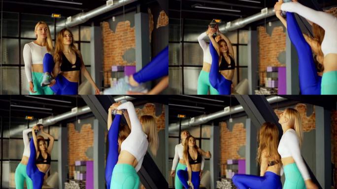 缩小个人教练的镜头，帮助女性客户在健身和舞蹈工作室的个人课程中站在镜子前进行垂直分割
