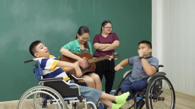 老师和残疾孩子在教室里弹吉他，非常高兴