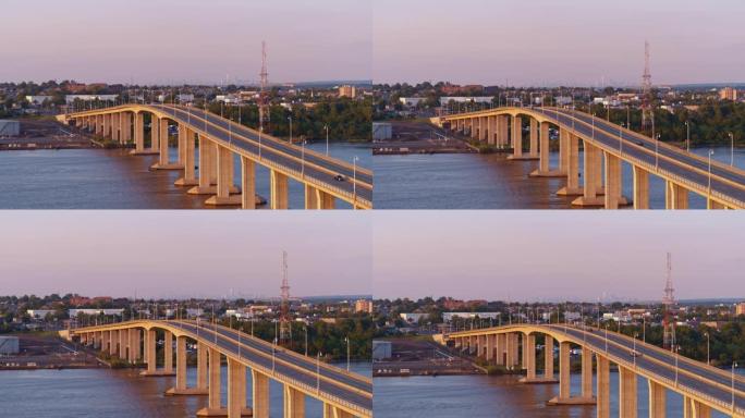 日落前的傍晚，在新泽西州拉里坦河上的胜利桥上鸟瞰图，背景是纽约市曼哈顿的遥远景色。带有前向摄像机运动