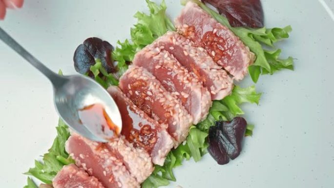 将烤金枪鱼和装饰蔬菜放在4k的盘子里。调味金枪鱼的概念，并补充不同的香料，香菜，葱，红辣椒，蒜片。