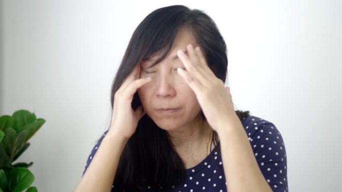 没有化妆的亚洲女性在家里感到恶心和头痛，生活方式的概念。