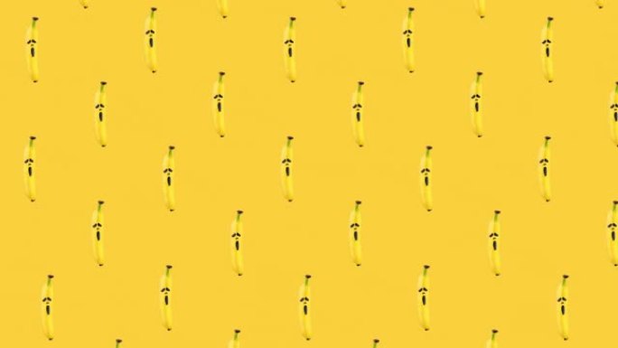 香蕉的无缝循环动画图案，上面画着黄色背景上可怕的恐惧面具。复制空间的万圣节概念