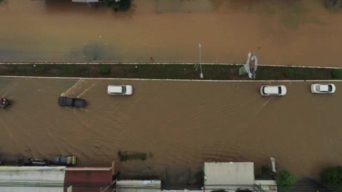 在洪水泛滥的道路上行驶的汽车的空中拍摄