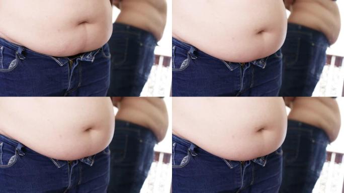 超重的女人检查她肚子上的脂肪。肥胖问题