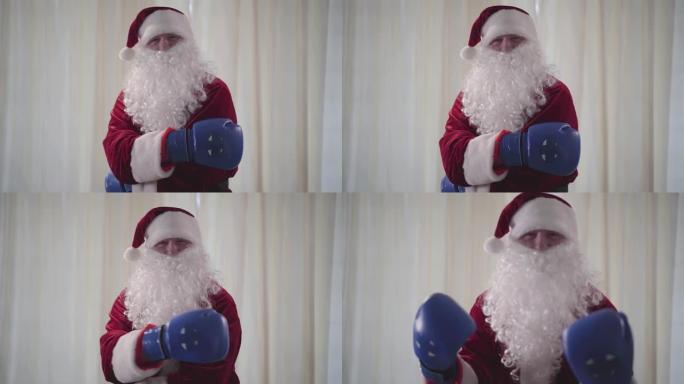戴着蓝色拳击手套的大胡子滑稽圣诞老人想打架。老人威胁地挥舞着双手。圣诞节，假期，坏圣诞老人