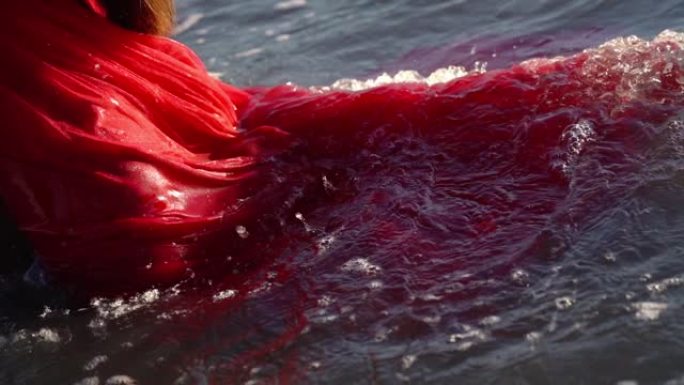 漂浮在海水上的蓬松连衣裙湿裙上的波浪卷