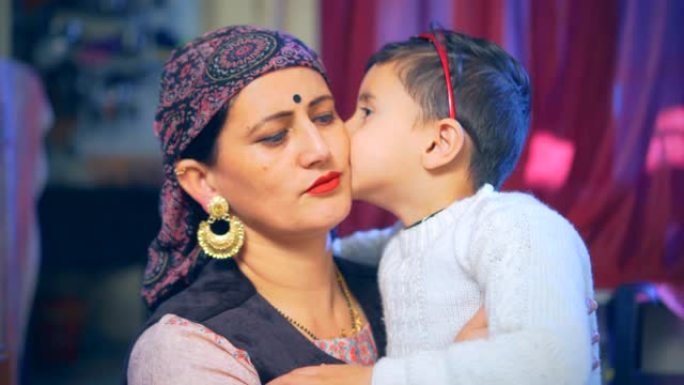 美丽的母亲和小儿子分享伟大的爱和幸福的吻。