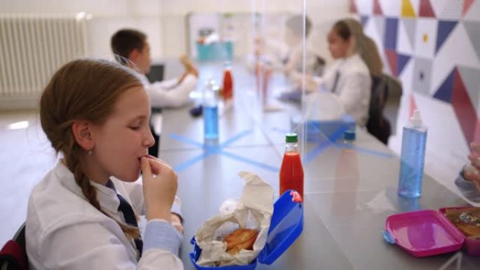 小学生在 “新常态” 学校环境中吃午餐