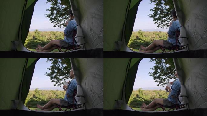 野营时坐在帐篷前放松的女人
