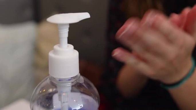 年轻漂亮的女商人在咖啡店使用洗手液作为适当的卫生礼仪