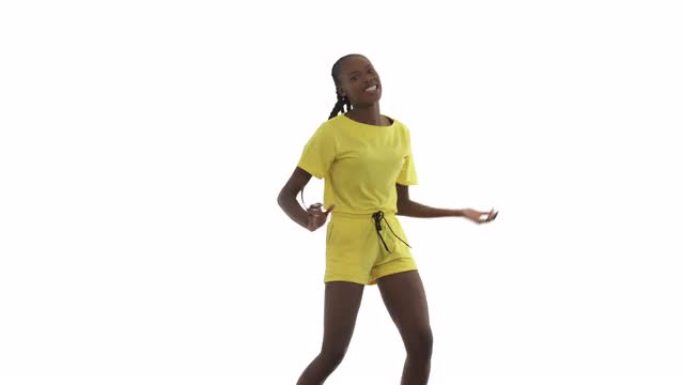 非洲女人以非洲风格跳舞。舞者做摇摆的步骤，小弹跳和剧烈摇摆。孤立在白色背景上。