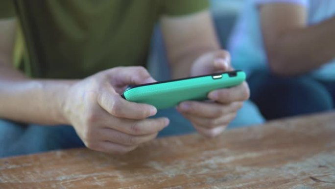 男人在等某人时使用智能手机。