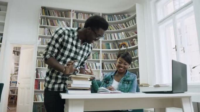 非洲人走到图书馆，给五个迷人的非洲女孩，并开始在图书馆一起学习