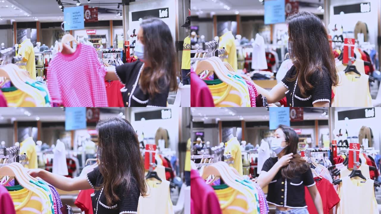 亚洲女性在服装店用口罩购物，新常态购物理念