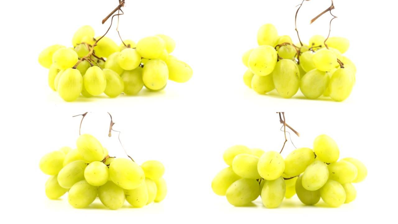 成熟多汁的葡萄在盘子上旋转。一串白葡萄的特写。新鲜一束多汁的葡萄在白色背景上旋转。