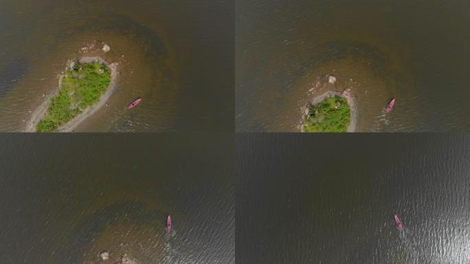 一个年轻人和他的儿子在海上或湖中的充气皮划艇中划桨