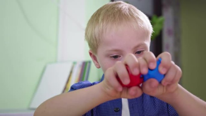 残疾男孩的肖像，患有唐氏综合症的孩子在家里近距离玩耍时露出舌头