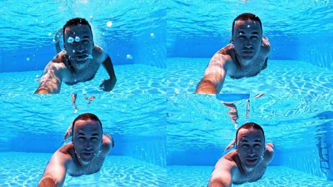 男子在游泳池里用水下摄像机游泳。