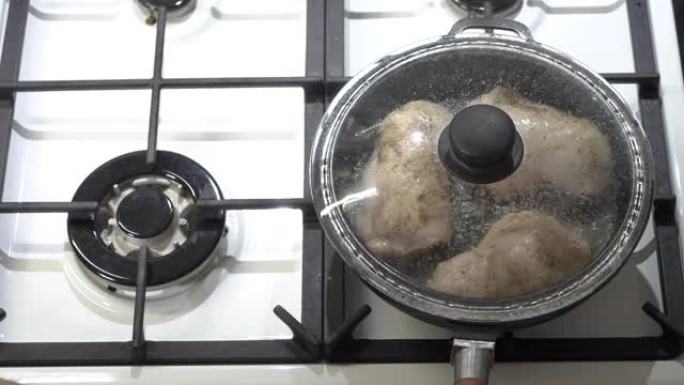 用玻璃盖顶视图的铸铁煎锅做煎锅鸡腿。
