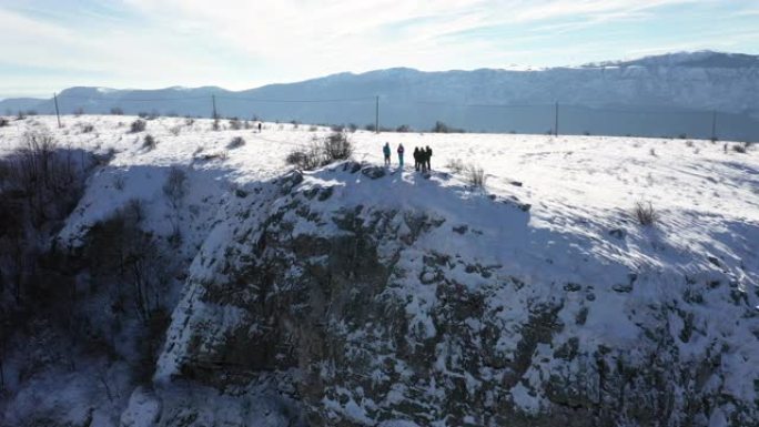一群徒步旅行者站在山崖上欣赏冬景