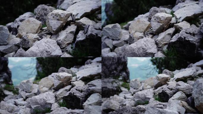 浅灰色的石头躺在阳光特写的山上