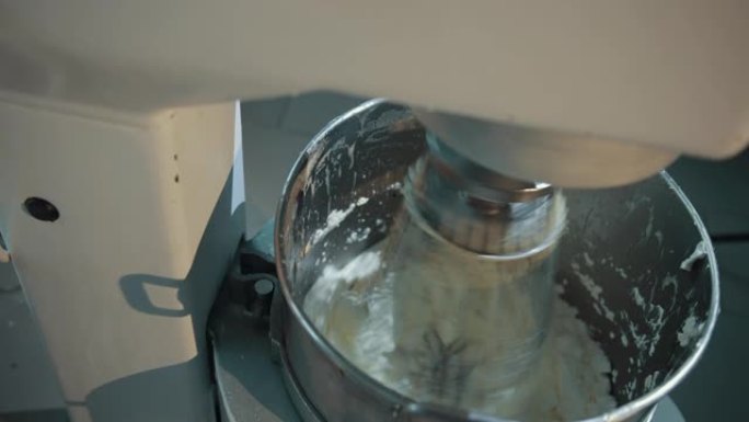 在不锈钢电动搅拌机中准备甜美美味的奶油。