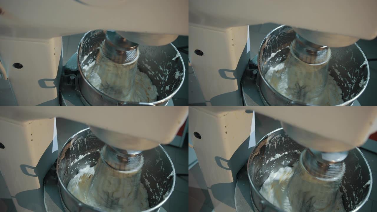 在不锈钢电动搅拌机中准备甜美美味的奶油。
