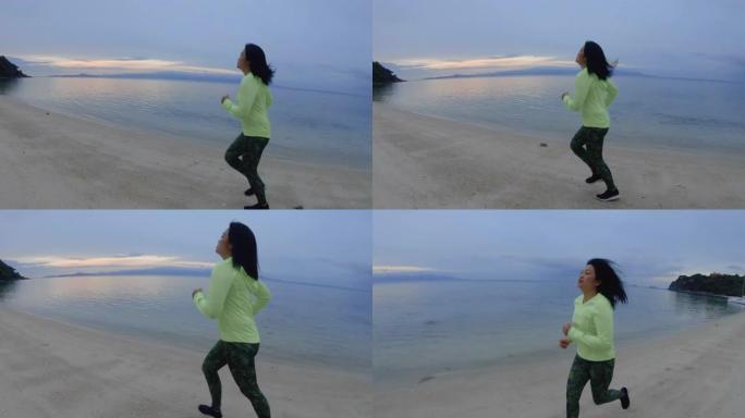 亚洲妇女早上在海滩上跑步运动。慢动作