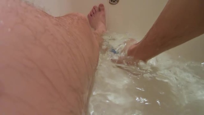浴室里的人。水下摄像机。悬挂双腿。