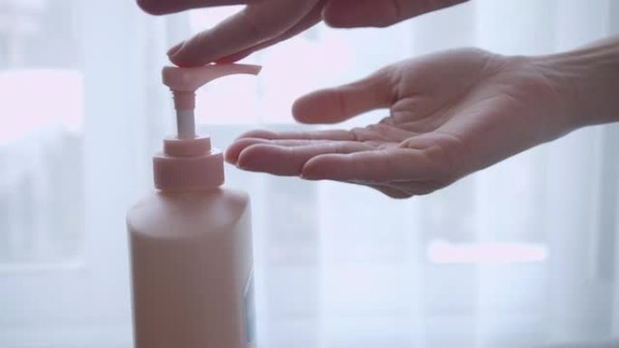 亚洲女性泵身体护理乳液在手上的白色背景。