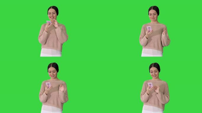 困惑的年轻女子在绿屏上使用智能手机，喜怒哀乐，色度键