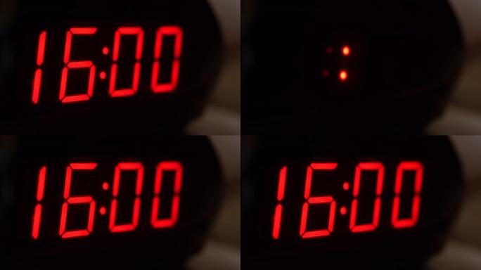 黑色数字时钟屏幕的特写显示16.00。黑色背景上闪烁红色数字。现代定时器系统和霓虹灯、电动报警装置