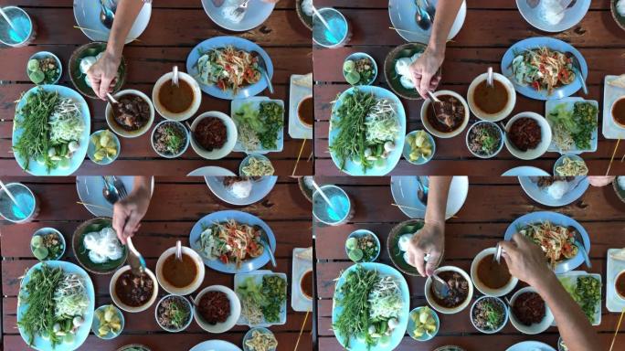 餐桌上的泰国菜: 吃东北食物 (麻辣木瓜沙拉，糯米饭，麻辣汤)。本地和传统方式。泰国菜背景。享受饮食
