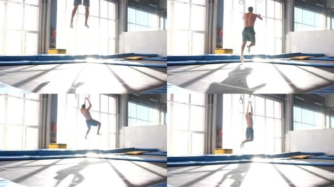 年轻的运动型男子在飞行公园的蹦床上跳跃和飞行