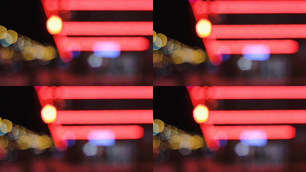 霓虹灯模糊了背景。夜晚的城市灯光。红色