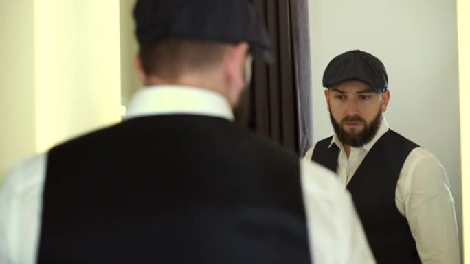 英俊的男人在试衣间的镜子里看着自己。