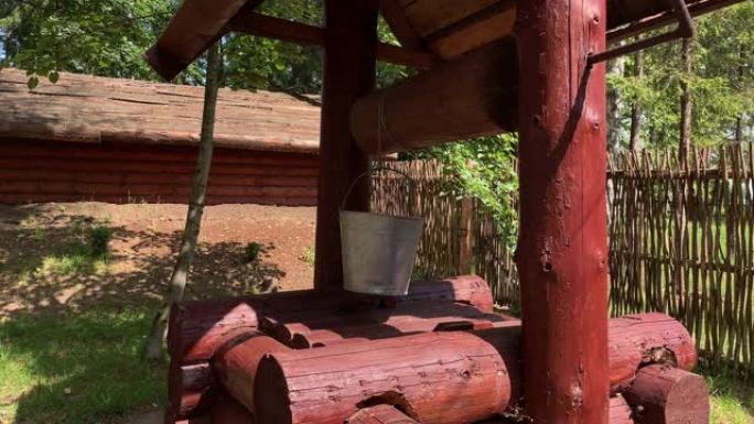 夏季晴天，在宅基地里，一个木制的乡村水井，用绳子上的水桶