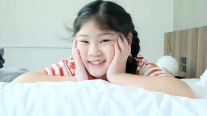 可爱漂亮的年轻亚洲女性休闲布舒适有趣的游戏与快乐和快乐在白色软床4k慢动作镜头
