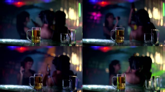 桌上一杯啤酒，背景模糊，女人跳舞